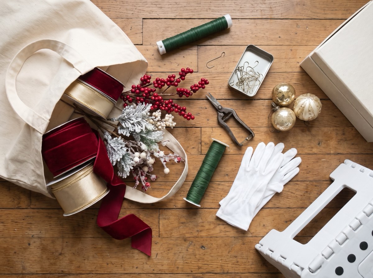 A decorator's tote tipped open with ribbon, picks, wire and snips